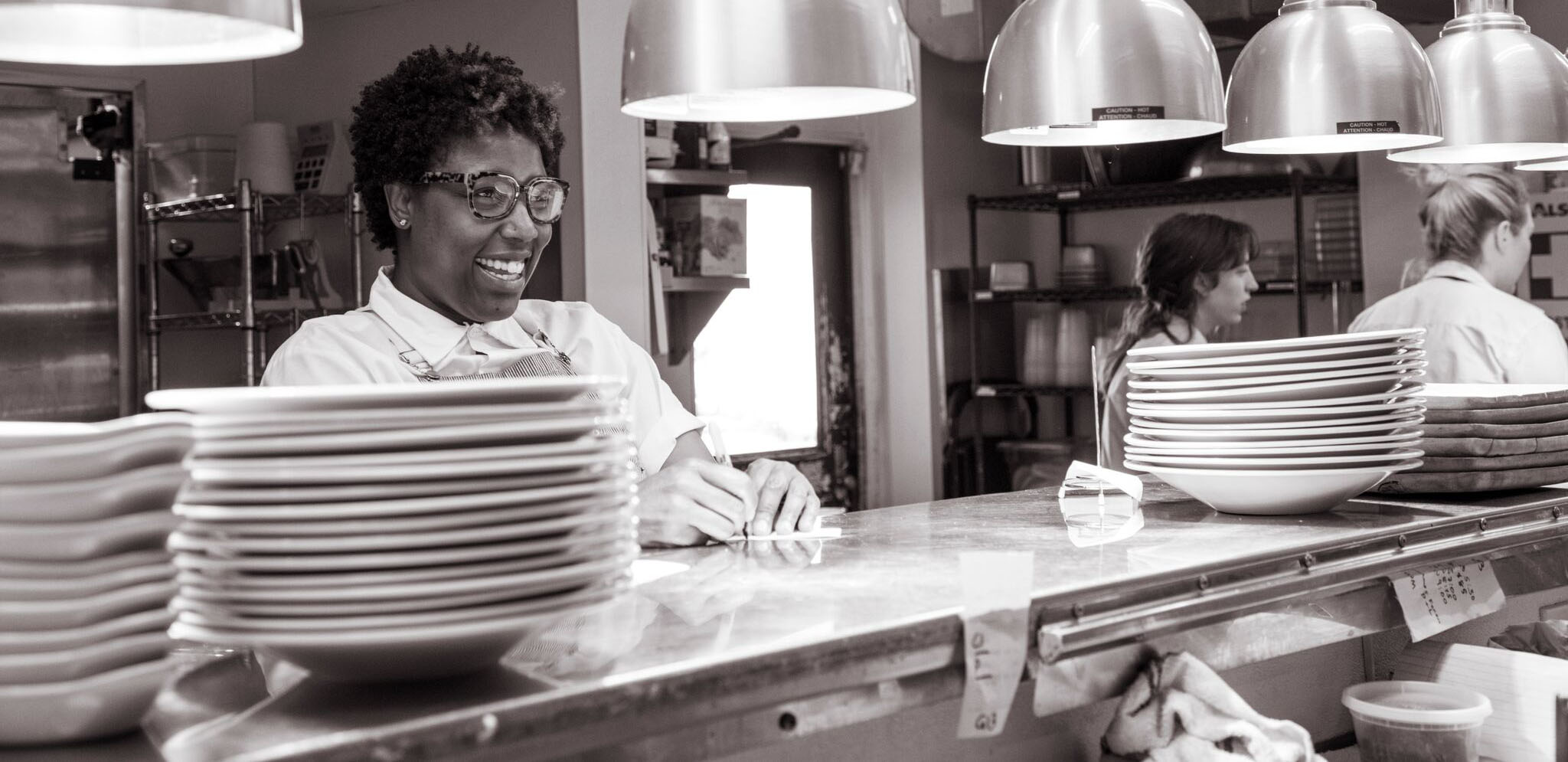 Chef Mashama Bailey smiles while working on the line at a restaurant