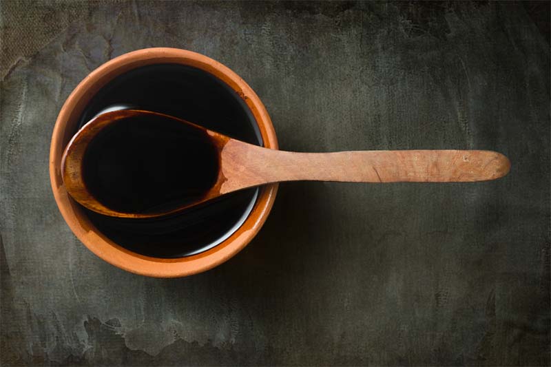 A spoon in a bowl of soy sauce.