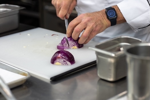 Purple onion on a cutting board in the ICE kitchen.