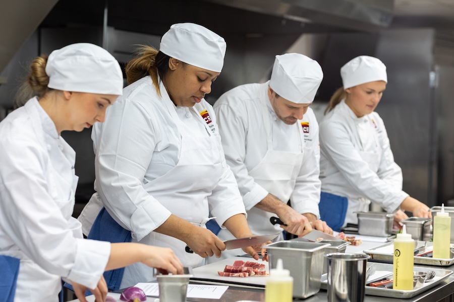 ICE students practicing knife skills in the kitchen.