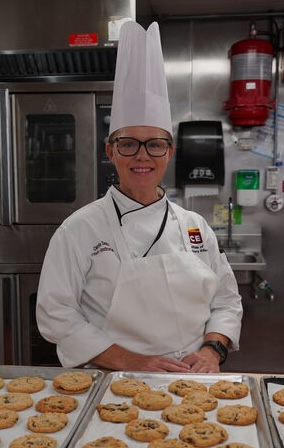 ICE Chef Carrie Smith in the kitchen in front of cookies.