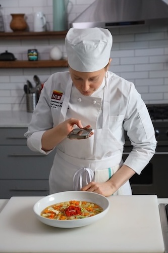 ICE student taking a picture of her dish.