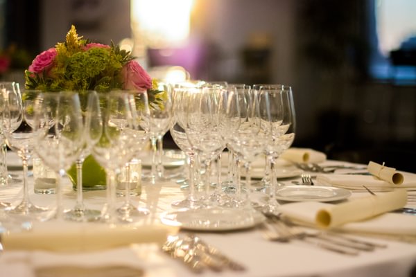 Fancy dining table with white table cloth and champaign glasses. 