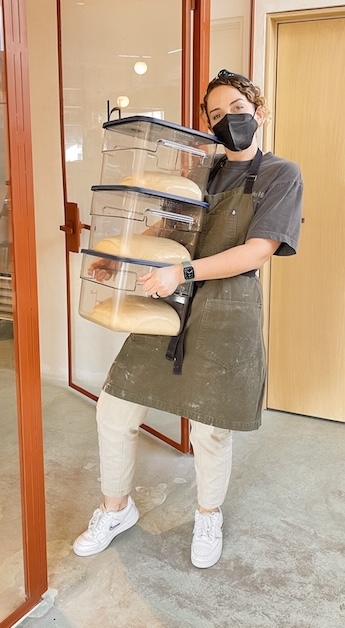 Carolina Buchanan Higuera carrying boxes of bread dough into her restaurant in Mexico.