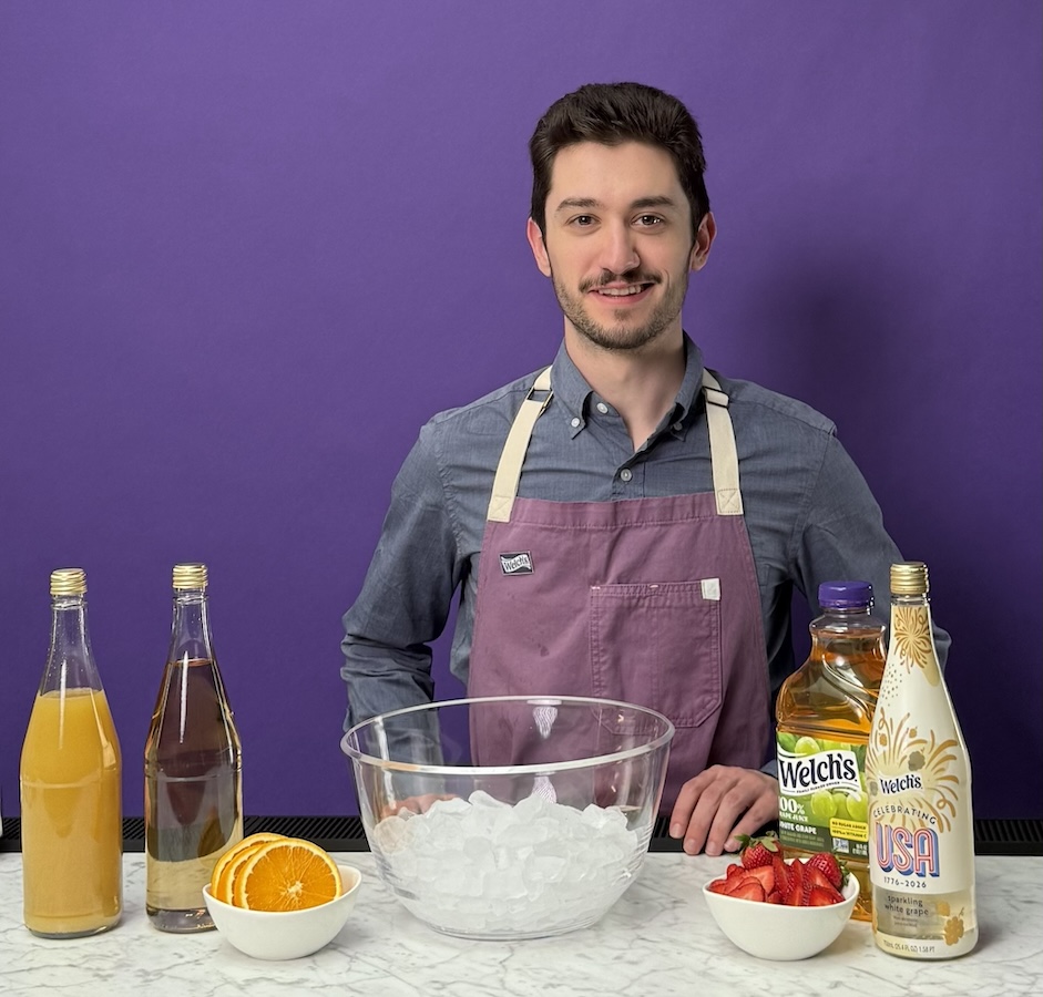 ICE alumnus Jon Chandler smiles on set, prepared to demonstrate food science concepts using fresh ingredients and Welch's products.