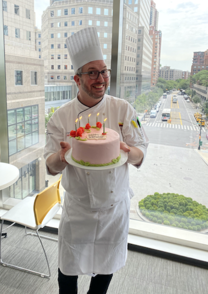 Chef Jurgen with a cake be made using edible flowers.