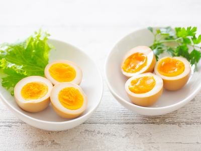 Image of soft-boiled eggs on a white plate with parsley leaves as garnish. 