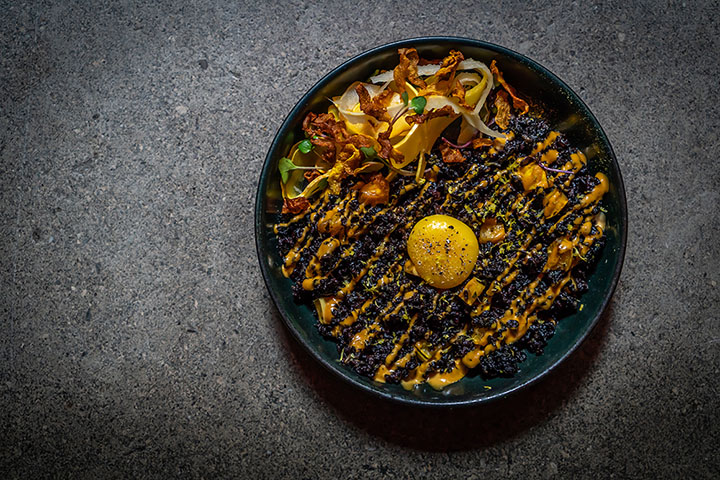 Chef Greg Proechel serves delicata squash in his Forbidden Rice with black vin aioli and egg yolk at Ferris.