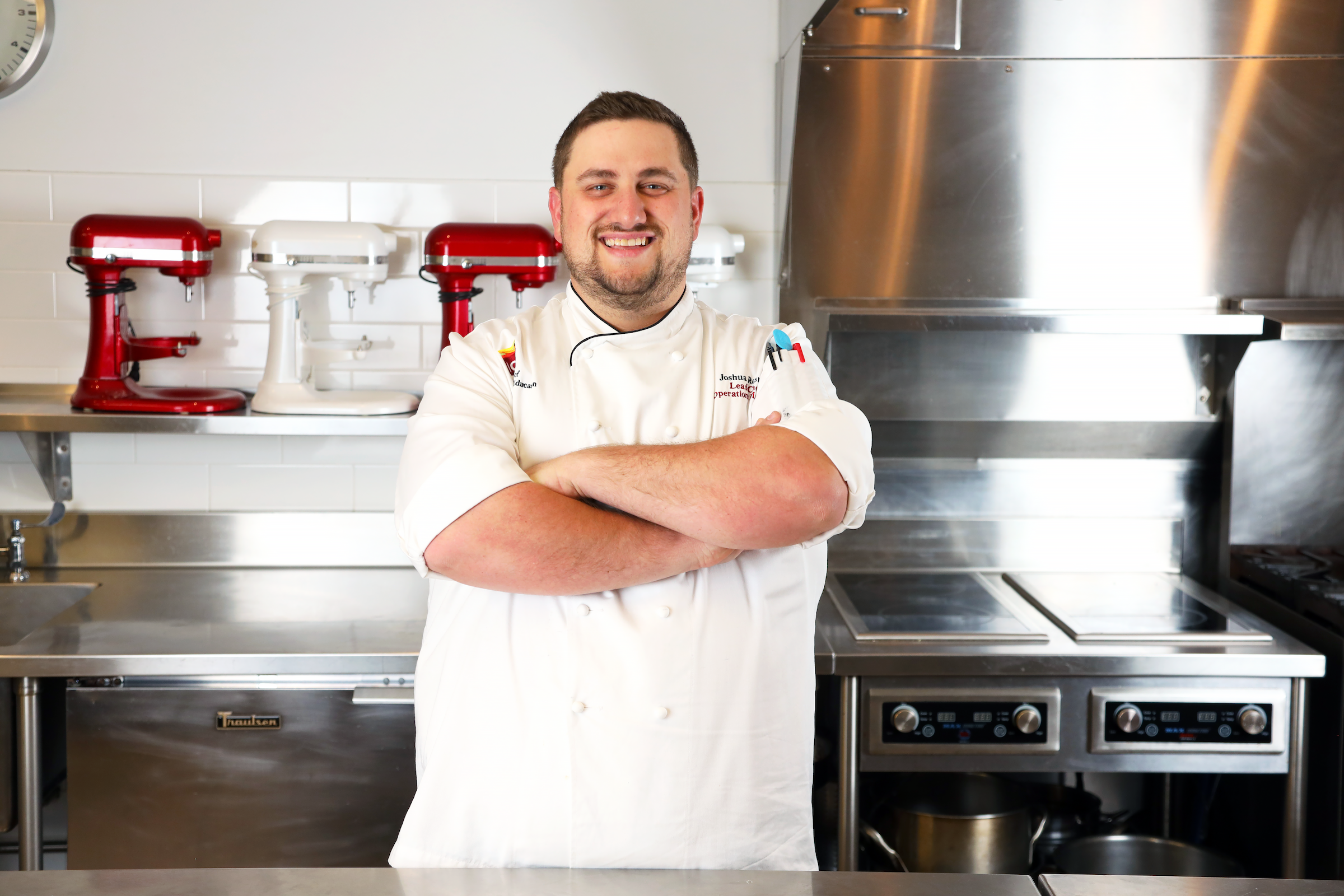 Chef-Instructor Joshua Resnick stands in a kitchen smiling