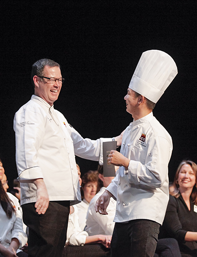 Chef Lachlan congratulates Matthew Leung at ICE's 2019 graduation commencement.