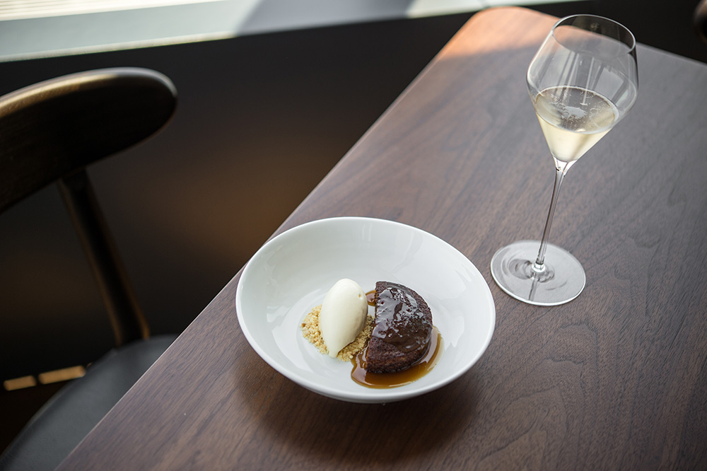 Emma serves warm date cake with crème fraiche ice cream and whiskey sauce at Manhatta. Photo by Daniel Krieger.