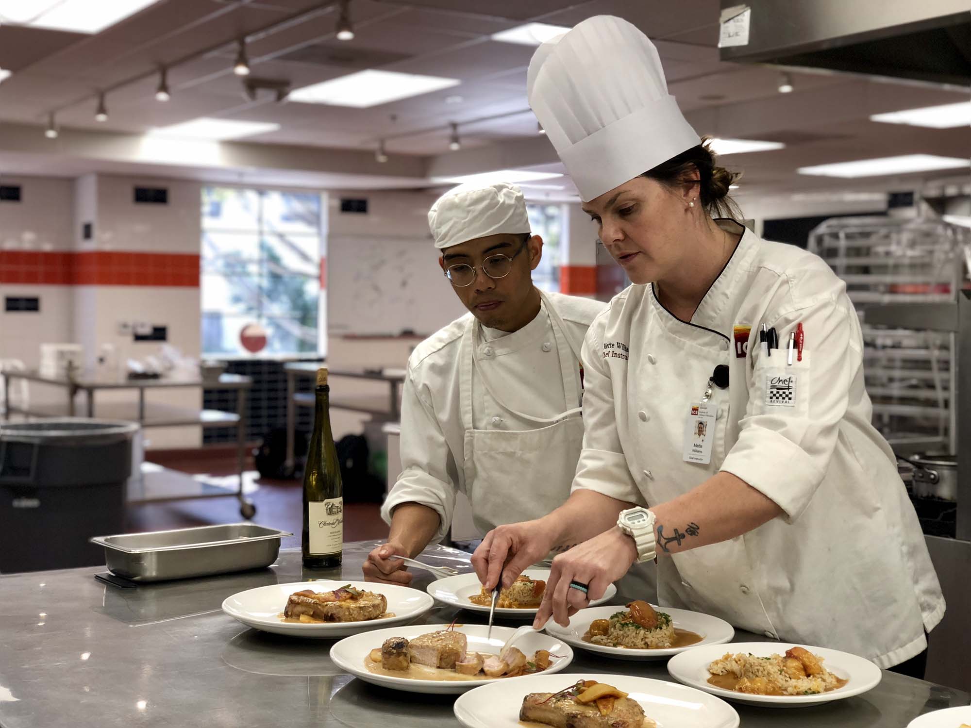 Chef-Instructor Mette Williams works with Culinary Arts students on a pork chop dish.