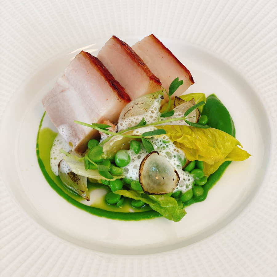 plate with pork belly and petits pois a la Francaise