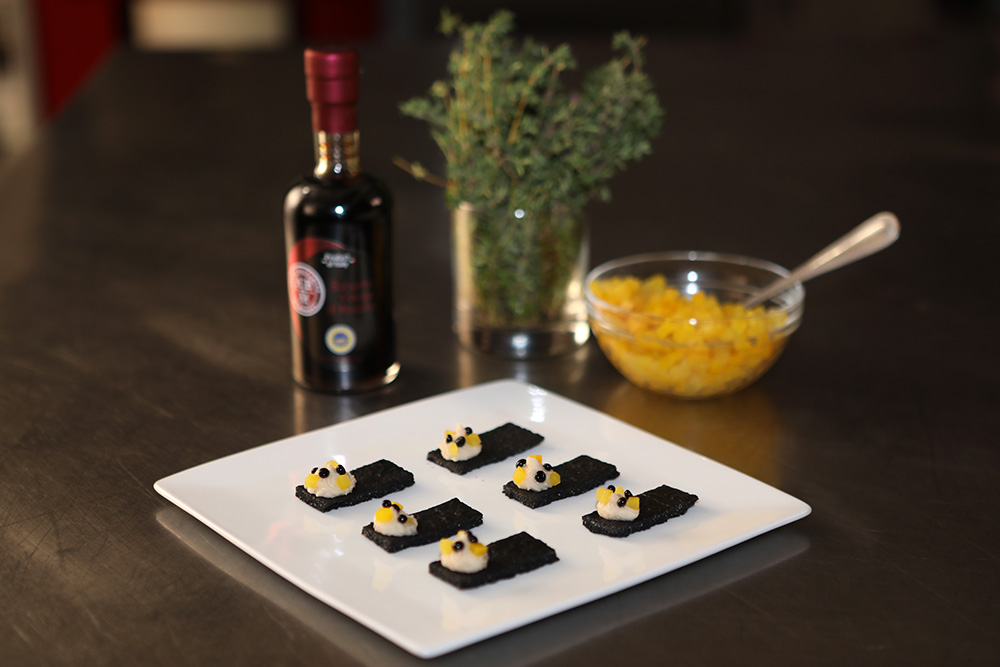 Balsamic Vinegar of Modena pearls with white bean puree and yellow beets on charcoal crackers.