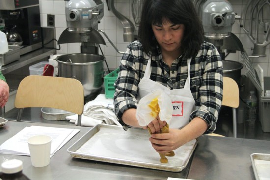 A student learns to pipe the pumpkin cookies for One Girl's whoopie pies.