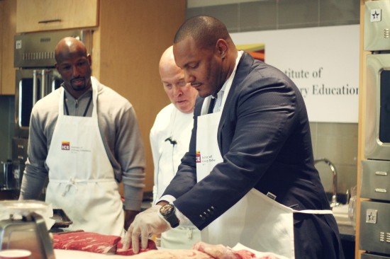 Chef Instructor Ted Seigel shows Jason Avant and Will Smith how to break down a boneless beef loin.