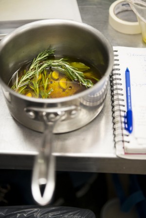 a saucepan filled with garlic rosemary and oil - a sauce being made in a professional kitchen in New York