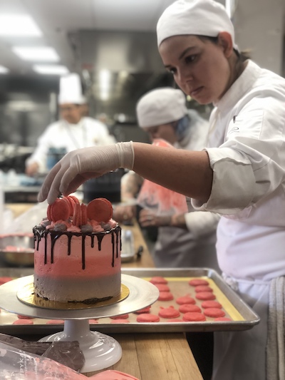 A student tops her ombre cake with macarons