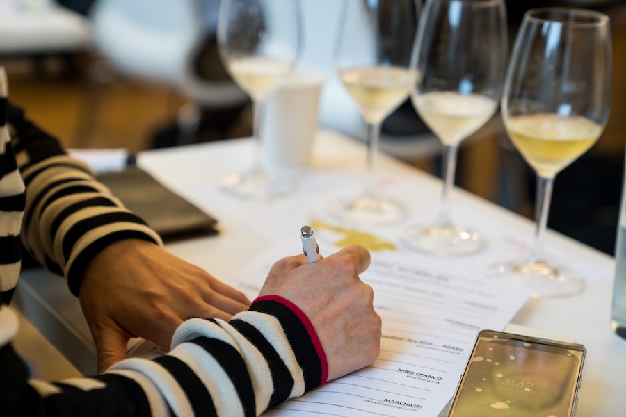 A student takes tasting notes while studying white wines.