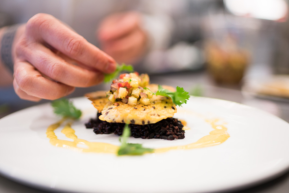 Chef Barbara Rich plates seared tempeh with cilantro.