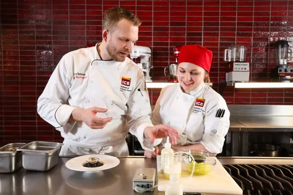 an ICE Chef-Instructor helps an Advanced Contemporary Cuisine & Technique student