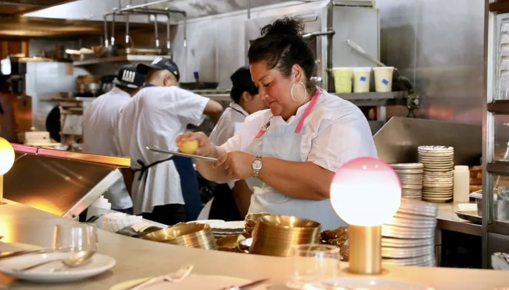 Chef Ayesha Nurdjaja working at her restaurant kitchen.