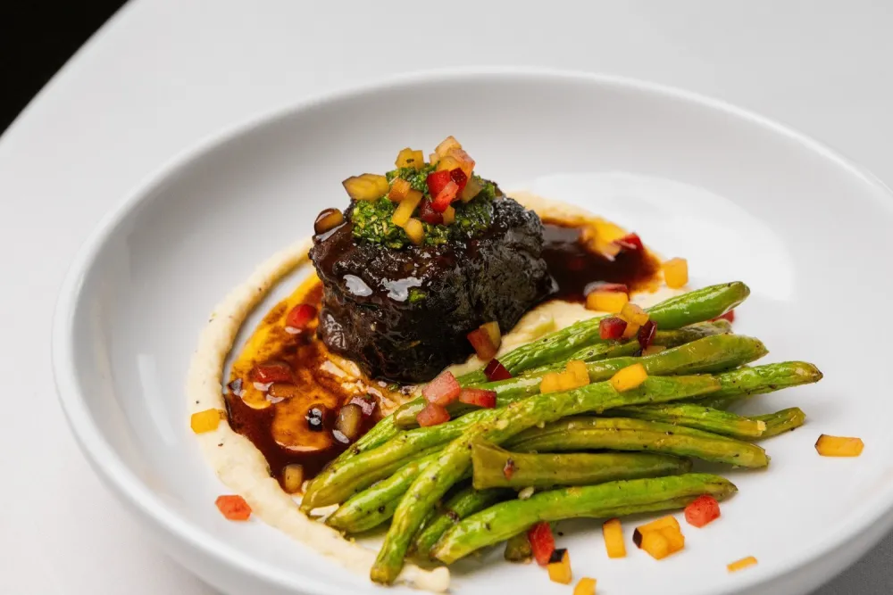 Plate with green beans, polenta, and steak.