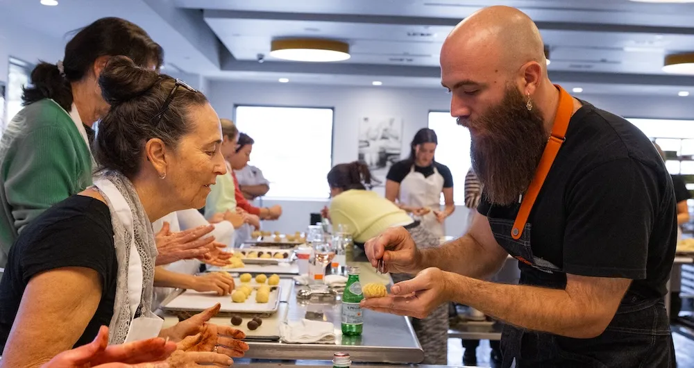 Ben Siman Tov shows a guest a culinary technique.