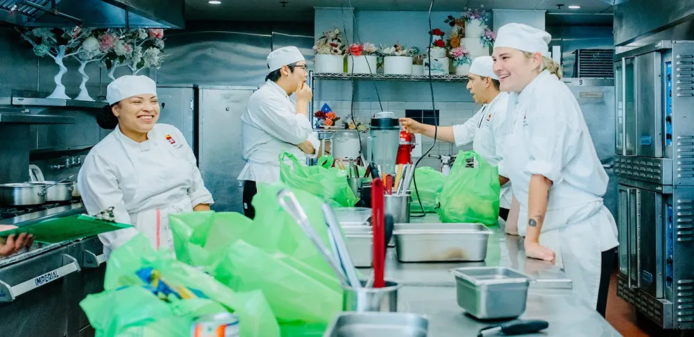 ICE students smile in a lab kitchen