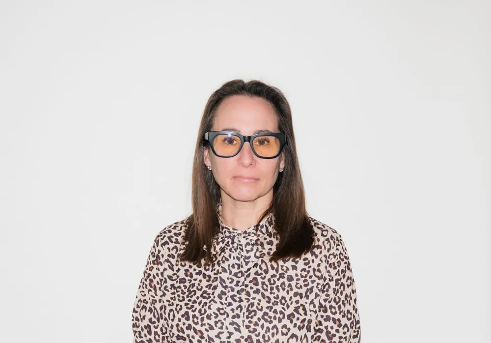Chef and restaurateur Rebecca Roth Gullo stands against white background wearing leapord print shirt and long brown hair.