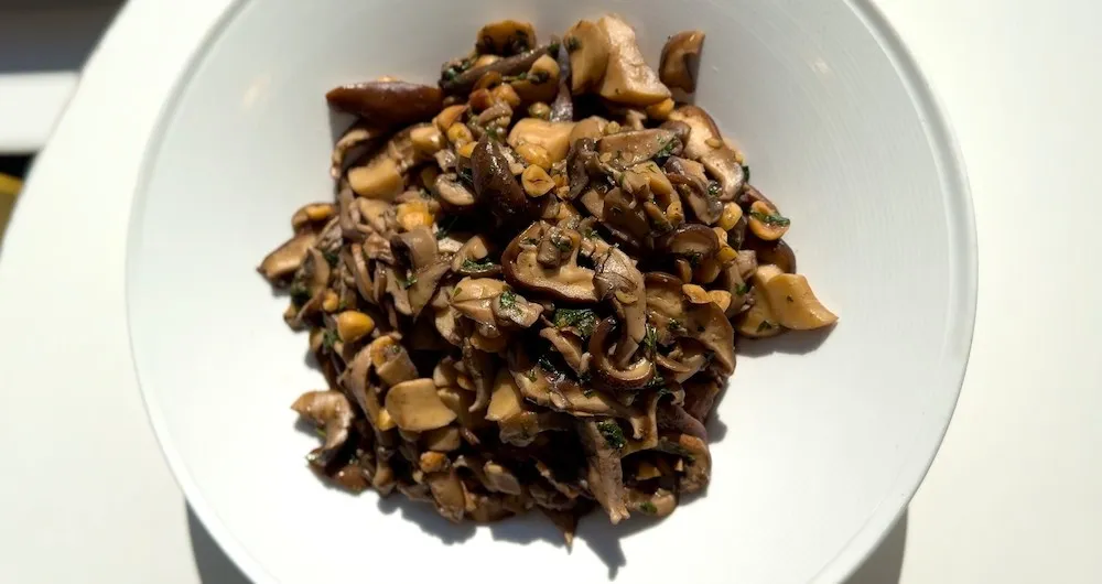Sautéed mushrooms and hazelnuts on a white plate