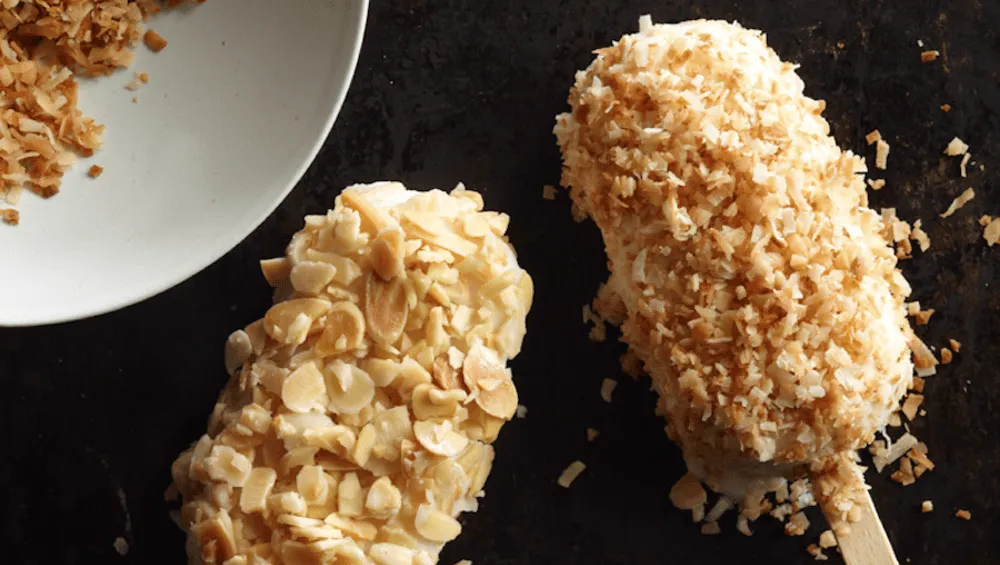 almond and coconut popsicles against a black background