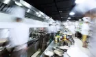 busy professional kitchen where chefs are preparing mise en place for dinner service