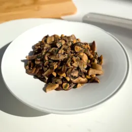 Sautéed mushrooms and hazelnuts on a white plate