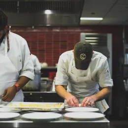 chef prepping plates in kitchen