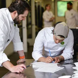 Chef and ICE student work on recipe plan for stuffed cabbage competition.