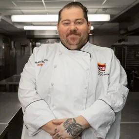 Chef-Instructor Vlad Vaynkhadler in chef whites in the kitchen. 