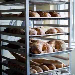 Freshly baked bread cooling on a speed rack in professional kitchen