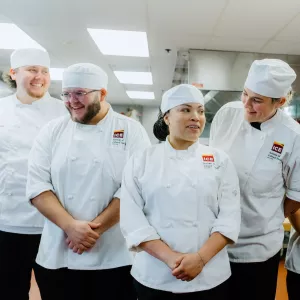 ICE students smile in a kitchen