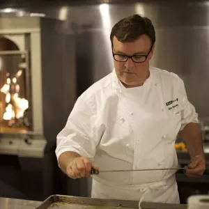 chef in a kitchen using the smoker