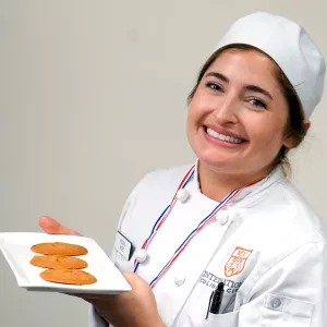 An ICC student poses with burnt honey cookies