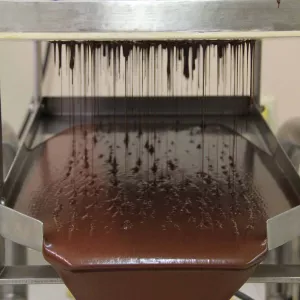 chocolate straining through machine after being made
