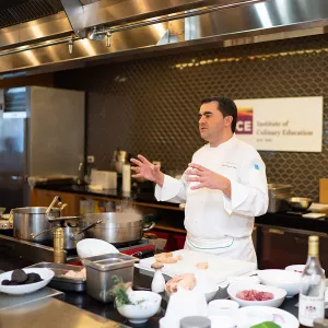 Chef Jean-François Bruel speaks to students at ICE during an Elite Chef demo