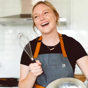 ICE alumna Katie Elliot holds a whisk and smiles
