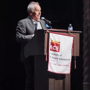Wolfgang Puck speaks to ICE graduates in Los Angeles.