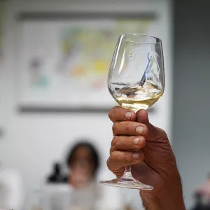 A hand swirls white wine in a glass