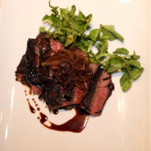 Grilled Skirt Steak with Balsamic Soy Marinade is plated with greens.