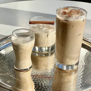 Three glasses of eggnog on a tray.