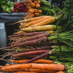 Colorful carrots line a farmers market stall.