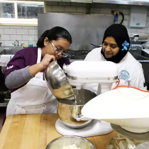 ICE alum Naseem Kapdi works with a student at Hot Bread Kitchen.